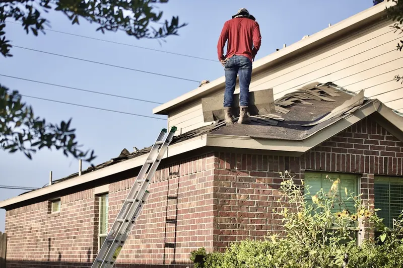 Professional roofer working on a residential roof in Orosi